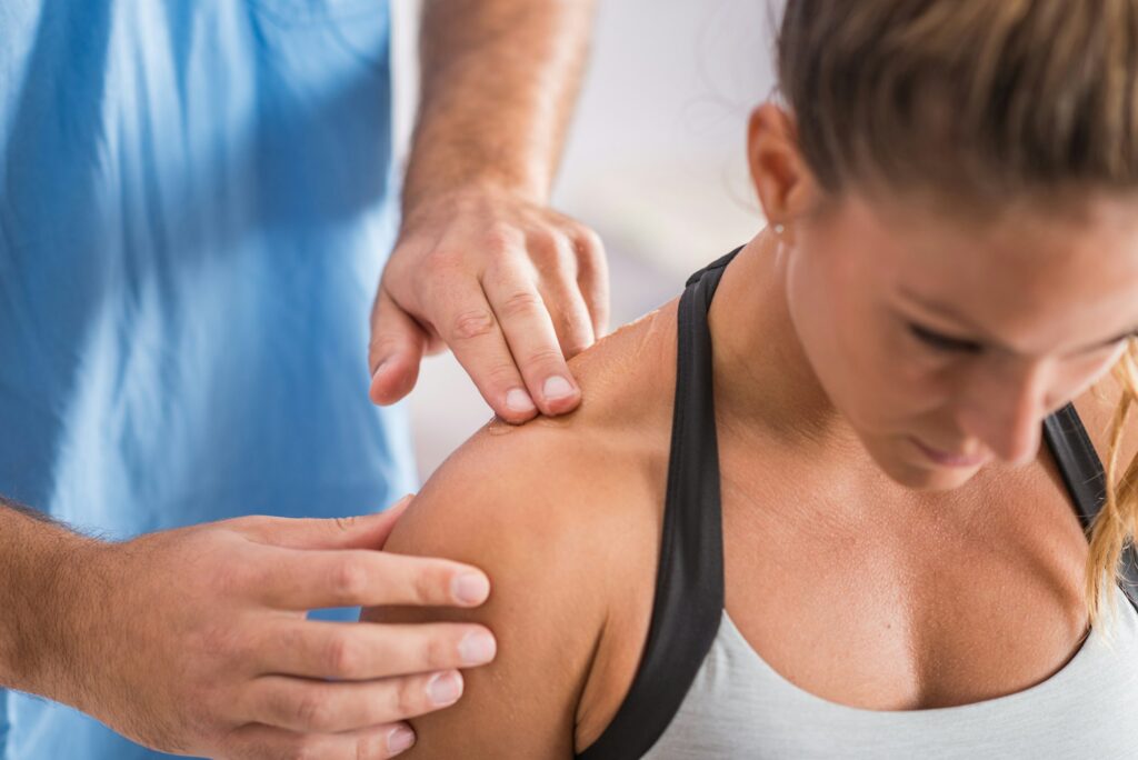 Physical therapy. Therapist addressing trapezius muscle